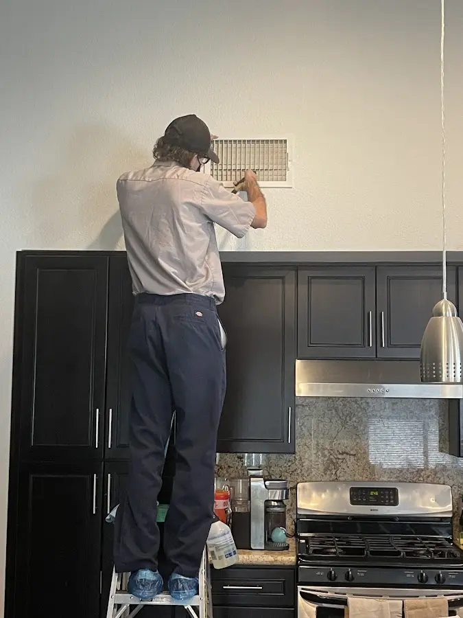 Technician inspecting an air vent during HVAC service in Pinellas Park